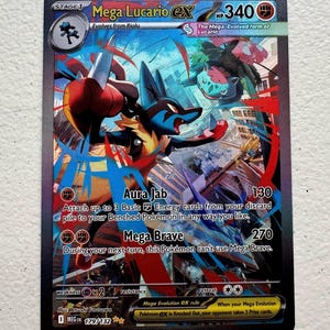 Peut inclure: Une carte à collectionner Pokémon Mega Lucario EX. La carte présente une illustration dynamique de Lucario en action, avec des couleurs vives et des œuvres d'art détaillées. La carte comprend du texte détaillant les attaques et les capacités, avec 340 PV.