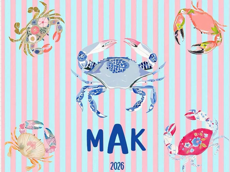May include: A whimsical design featuring five illustrated crabs in various colors and patterns against a striped background of pink and light blue. The word "MAK" and the year "2026" are displayed in blue.
