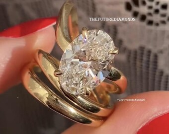 May include: A gold ring featuring a large oval-cut diamond held by four prongs, set on a smooth, polished gold band. The text THEFUTUREDIAMONDS is visible on the image, along with the phrase saying YES! with sparkle icons near the top edge.