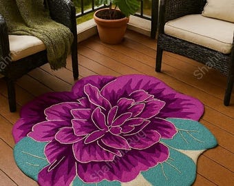 May include: A purple flower-shaped rug with teal green leaves on a wooden deck. The rug has a detailed floral design. Two black wicker chairs and a potted plant are in the background.