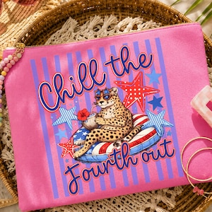 Könnte beinhalten: Eine pinkfarbene Reißverschlusstasche mit den Worten "Chill the Fourth out" in blauer Schrift. Die Tasche zeigt einen Geparden mit Sonnenbrille, der sich auf einem patriotischen Schwimmring entspannt, umgeben von Sternen.