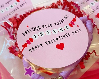 May include: A pink and purple friendship bracelet with gold beads and a star charm. The bracelet is packaged in a clear plastic bag with pink tissue paper and a pink and white sticker that says "Prettay Glad You're My Friend Happy Valentine's Day!"