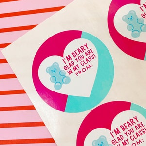May include: Two pink and blue heart-shaped stickers with a gummy bear illustration and the text "I'm Beary Glad You Are In My Class!" and "From:"
