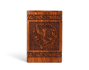 May include: A rectangular wooden box with a carved hummingbird design. The box is made of dark brown wood with intricate floral and leaf carvings around the edges and the hummingbird image. The box is a decorative item.