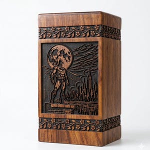 May include: A wooden box with a carved Batman scene. The box is brown with floral and leaf carvings at the top and bottom. The center panel features Batman standing in front of a full moon and a city skyline.