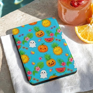 May include: A rectangular e-reader case featuring a bright blue background with a repeating pattern of smiling suns, jack-o'-lantern pineapples, ghosts, watermelon slices, pink hibiscus flowers, and small beach balls.