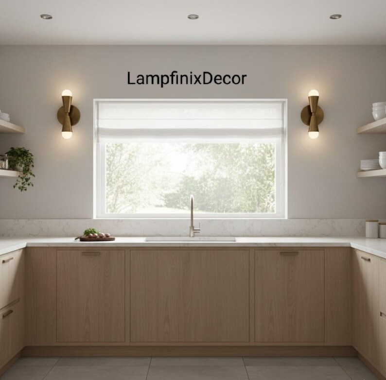 May include: A contemporary kitchen featuring light wood cabinets, a white worktop, and a large window. Two gold wall lights with spherical bulbs are positioned either side of the window. The text "LampfinixDecor" is above the window.