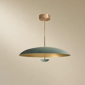 Op de afbeelding: Een moderne hanglamp met een teal-kleurige, schotelvormige kap en een goudkleurig interieur. De lamp heeft een messingkleurige plafondbevestiging en een slanke stang. Het ontwerp is minimalistisch en elegant.