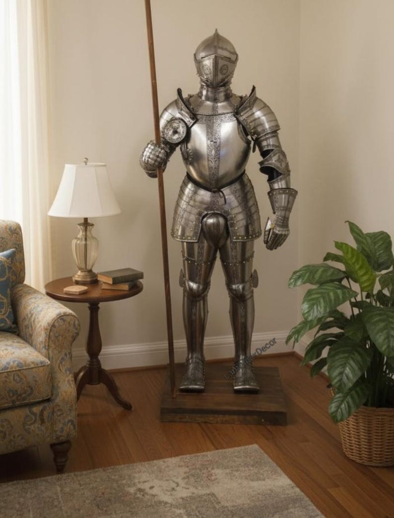 May include: A full suit of medieval armor made of polished metal, standing on a wooden base. The armor includes a helmet, chest plate, and leg protection. It holds a long wooden spear. The suit is a decorative item.