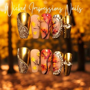 May include: A collection of false nails with diverse designs. Some are gold with glitter, others feature autumn tree art, and some have rhinestone accents. The text "Wicked Impressions Nails" is written in cursive at the top.