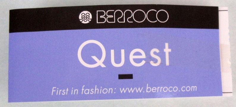 May include: A purple and black tag with the text "Berroco Quest" and the website "www.berroco.com". The tag reads "First in fashion".