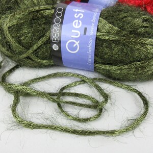 May include: A skein of green yarn with a metallic sheen. The yarn is labelled "Quest" and "Berroco".