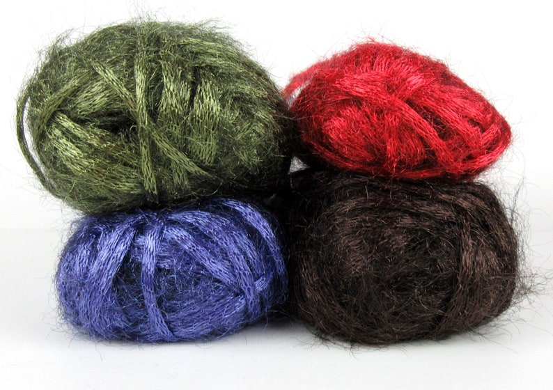 May include: Four balls of yarn stacked on top of each other. The top ball is red, the next is brown, the next is blue, and the bottom ball is green.