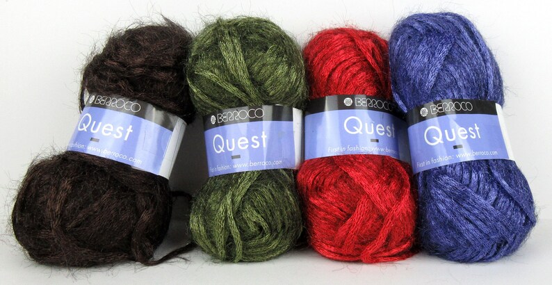 May include: Four skeins of yarn in different colours: brown, green, red, and blue. Each skein has a label that reads "Quest" and "Berroco".