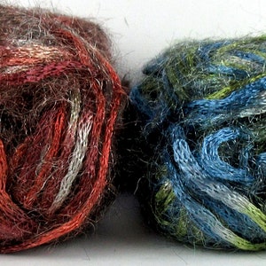 May include: Two balls of yarn, one brown with red and white stripes, the other green with blue and white stripes.
