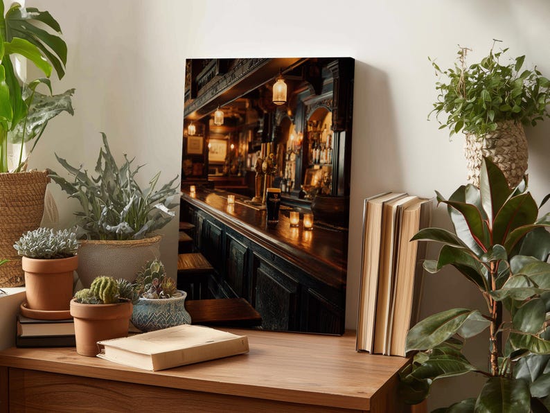 a cozy indoor setting with a wooden table, a bookshelf, and a potted plant. On the table, there are a few books, a small plant, and a candle, creating a warm and inviting atmosphere. The background of the image shows a bar scene with a counter, a barstool, and a lamp, suggesting a relaxing and comfortable environment.
