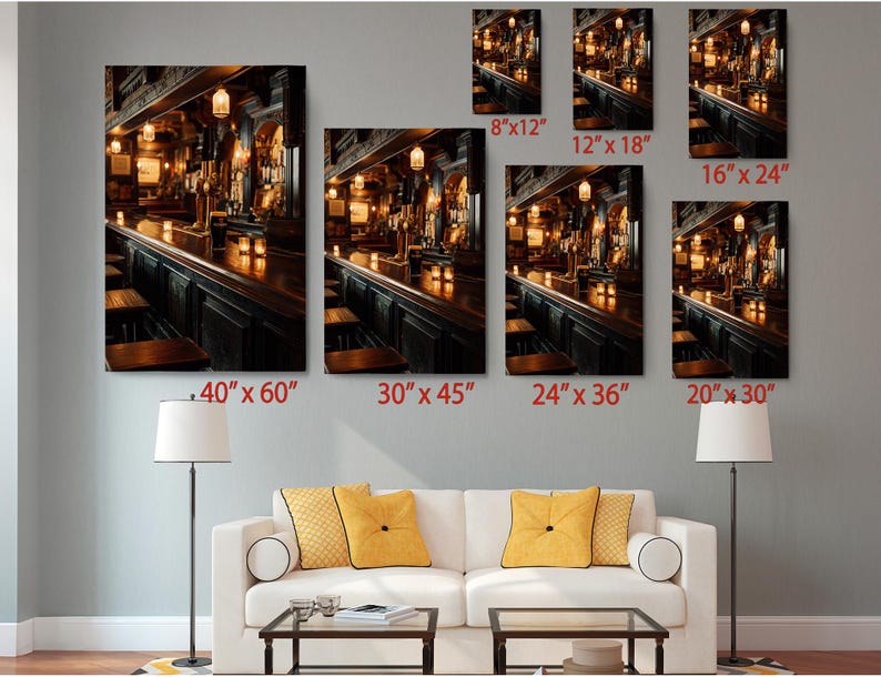 The image is a living room with a white sofa and a coffee table, and there are multiple framed photographs of a bar scene displayed on the wall above the sofa.