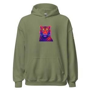 May include: An olive green hoodie with a colourful tiger graphic on the front. The tiger design uses red, orange, purple, and blue. The sweatshirt has a kangaroo pocket and a drawstring hood.
