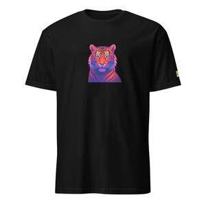 May include: Black t-shirt with a colourful tiger graphic. The tiger is rendered in shades of pink, orange, purple, and blue, contrasting against the dark fabric. The shirt has a classic crew neck and short sleeves. A small tag is visible on the sleeve.