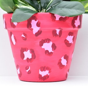 May include: A set of three ceramic mugs with a speckled, matte finish. The mugs are in shades of cream, light gray, and dark gray. Each mug has a simple, minimalist design and a rounded handle.