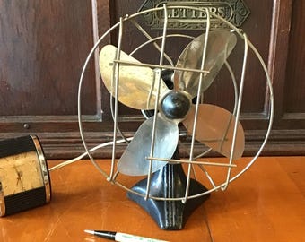 Monarch chrome four blade single speed tilting head table fan. Classic 1920s Art Deco style open cage design. 10 inches tall.