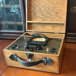 Supreme Model 541 Ohms Volts snd Milliamperes Meter in original dovetailed  Oak Box with latch. Vintage Gauge.