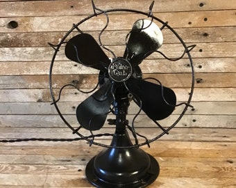 Polar Cub by A C Gilbert Co black four blade single speed table fan. Classic 1920s style open cage design. 12 inches tall, compact powerful.