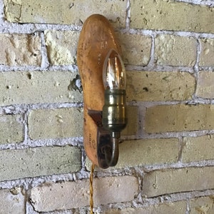 May include: A wooden shoe-shaped lamp with a light bulb and a cord. The shoe is labelled "8 AA".