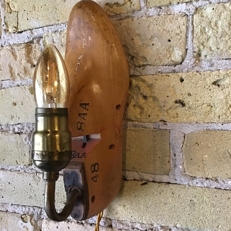 May include: A wooden shoe-shaped lamp with a light bulb and a metal arm. The shoe is labelled "8AA" and "48".