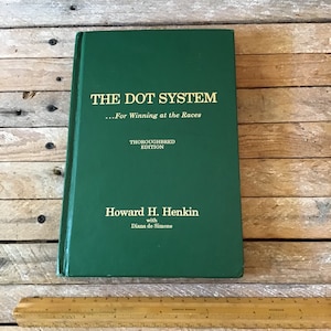 May include: A green hardback book titled "The Dot System...For Winning at the Races" with the words "Thoroughbred Edition" and "Howard H. Henkin with Diana de Simone" printed in gold.