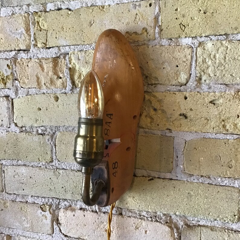 May include: A wooden shoe-shaped lamp with a light bulb and a cord. The shoe is labelled with the numbers "8", "48", and "8 1/2 A".