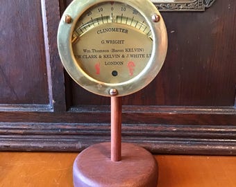 Clinometer by G Wright London. Brass face and case. Mounted on wood pedestal, excellent condition, authentic industrial.