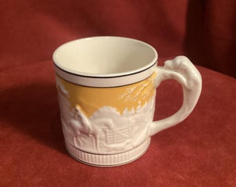 Reverse Yellow Etruria style cup with dog handle in detailed hunting scene pattern. Mystery ceramic, yellow background 3.25 inches tall.