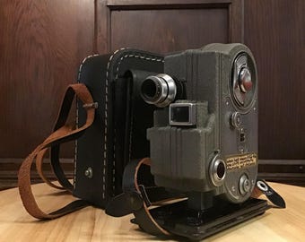 Cinemaster ll 8mm windup Movie Camera with all metal body single lens camera with carrying case and stand. F 1.9 lens. Early movie camera.