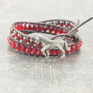 May include: A red and turquoise beaded wrap bracelet with a silver horse charm.