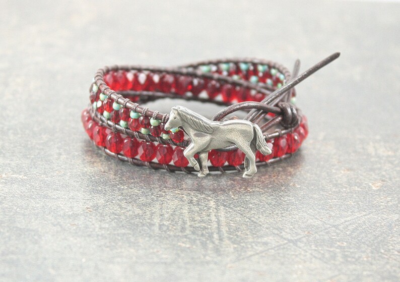 May include: A red and turquoise beaded wrap bracelet with a silver horse charm.