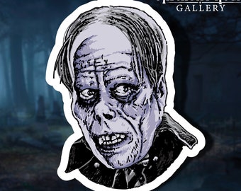 May include: A sticker featuring a black and white illustration of a pale, ghoulish-looking man with a furrowed brow and a wide, toothy grin. The sticker has a white border and the text "MIDNIGHT HOUR GALLERY" in white lettering at the top.