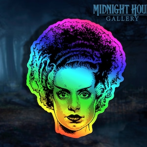 May include: A rainbow-colored sticker featuring a black and white illustration of the Bride of Frankenstein. The sticker has a glossy finish and is perfect for adding a spooky touch to any surface.