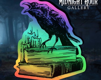 Puede incluir: Un cuervo negro con un acabado arcoíris iridiscente posado en la parte superior de una pila de tres libros. El libro superior tiene una vela encima. Los libros son viejos y tienen un aspecto vintage. El cuervo mira hacia la derecha y tiene el pico abierto. El texto "E.A. POE" es visible en el libro inferior. El fondo es un bosque oscuro con una imagen borrosa de árboles.