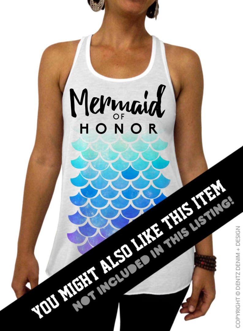 May include: White tank top with the text "Mermaid of Honor" in black script. Below the text is a mermaid scale design in shades of blue and purple. A fun top for a bachelorette party or bridal event.