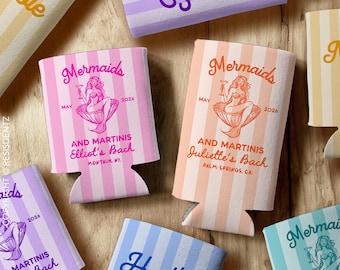 May include: Six colorful striped can coolers with mermaid illustrations and text that reads "Mermaids and Martinis" followed by the bride's name and location. The text also includes the date "May 2026". One cooler has the text "Heather" in blue.