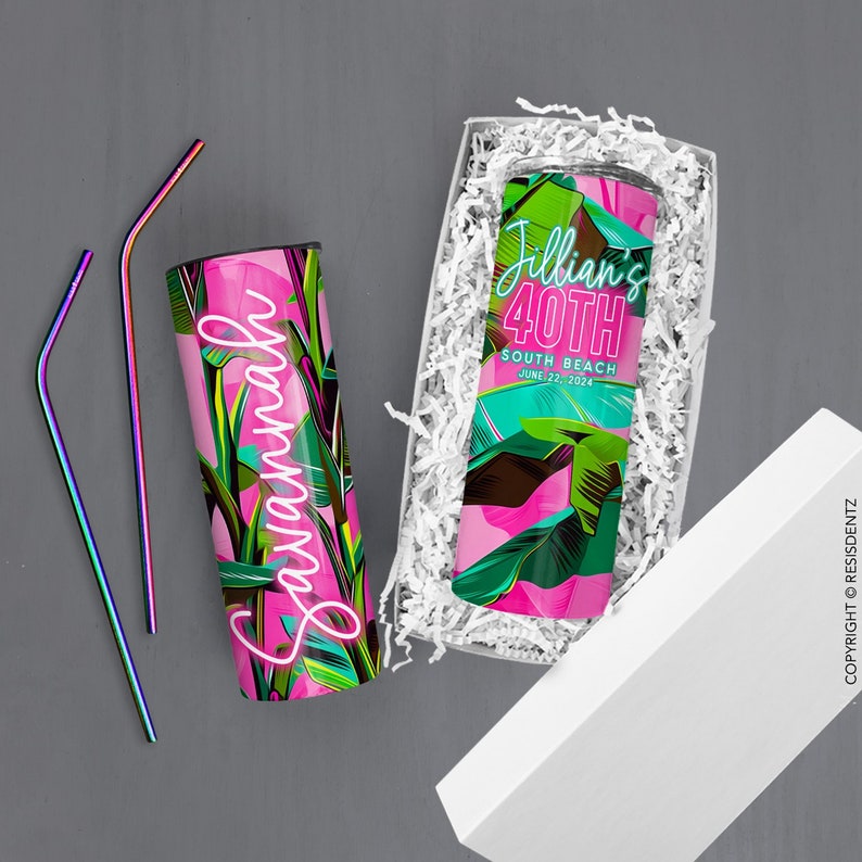 Pu&ograve; includere: Un bicchiere con motivo a foglie tropicali rosa e verde con il nome "Savannah" in lettere rosa neon. Il bicchiere &egrave; in una scatola regalo bianca con carta da imballaggio bianca. Due cannucce di metallo iridescenti sono accanto alla scatola.