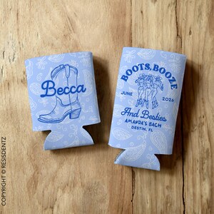 May include: Two blue and white patterned can coolers. One cooler features the text "Boots, Booze" with a June 2026 date and the text "And Besties Amanda's Bach Destin, FL". The other cooler features a blue and white cowboy boot with the name "Becca" written above it.