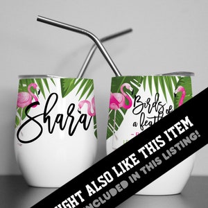 May include: Two stainless steel wine tumblers with pink flamingos and green palm leaves. One tumbler has the name "Shara" written on it. The other tumbler has the text "Birds of a feather" written on it.