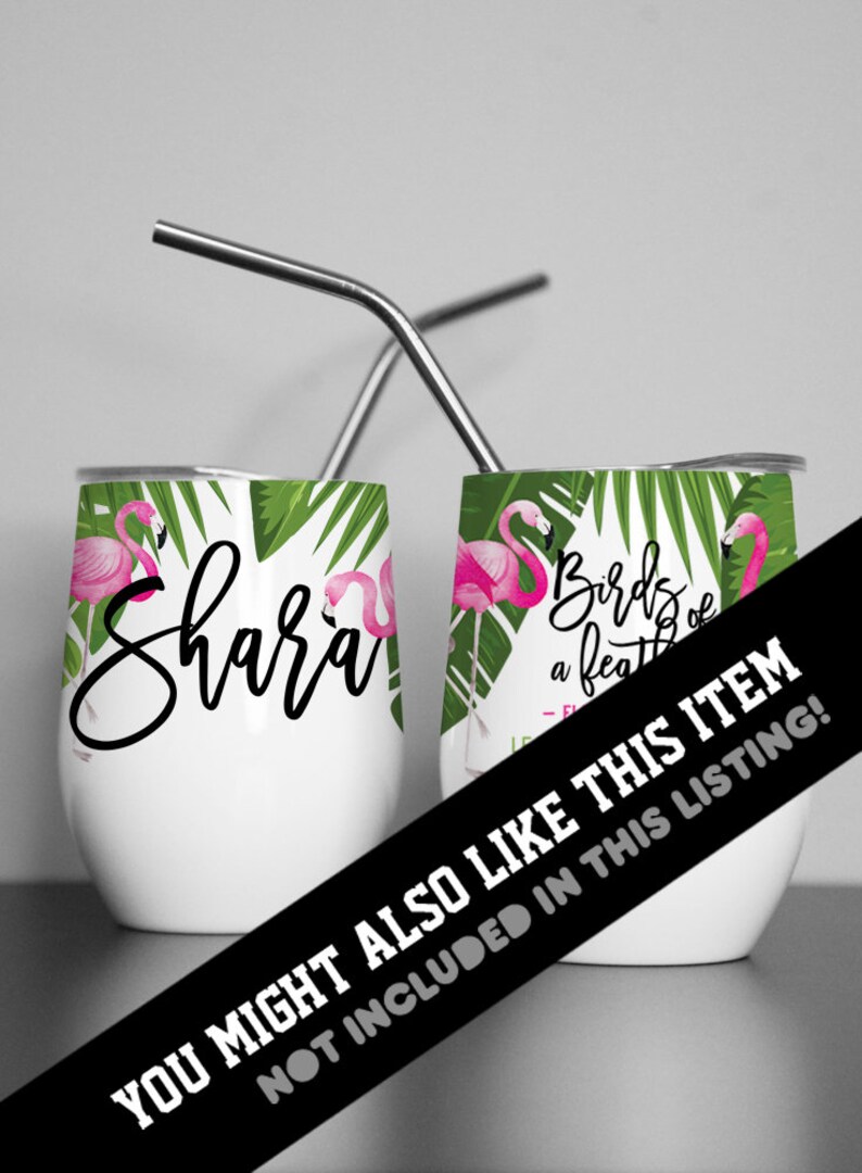 May include: Two stainless steel wine tumblers with pink flamingos and green palm leaves. One tumbler has the name "Shara" written on it. The other tumbler has the text "Birds of a feather" written on it.