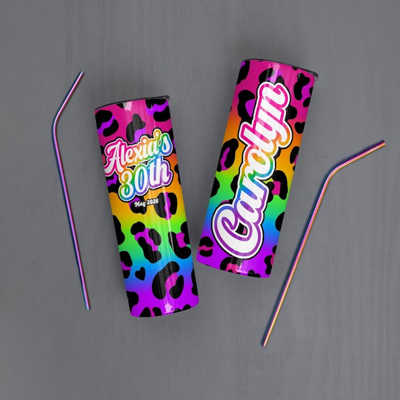 May include: Two stainless steel tumblers with rainbow leopard print design. One tumbler has the text "Alexia's 30th" and the other has the name "Carolyn". Two rainbow-colored straws are also included.