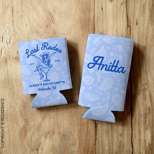 Personalized Last Rodeo bachelorette can cozies featuring a Western-themed design with a paisley background and a cowgirl in a martini glass. Customizable with names, event details, and available in multiple colors. Designed for slim and standard 12oz cans, these insulated drink holders are perfect for bachelorette parties, birthdays, and country music festivals.