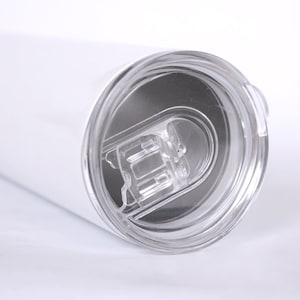 May include: White stainless steel tumbler with a clear lid. The lid has a small opening for sipping.