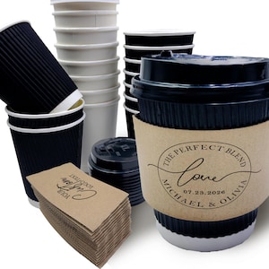 以下が含まれることがあります： 使い捨てコーヒーカップとアクセサリーの詰め合わせ。 黒い段ボールカップ、白い紙コップ、黒い蓋、茶色のカップスリーブが含まれています。 1つのカップスリーブには「The Perfect Blend Love Michael & Olivia 07.23.2026」というテキストが表示されています。
