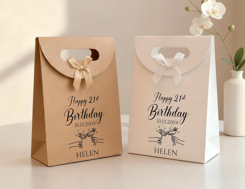 Pode incluir: Duas sacolas de presente, uma bege e outra branca, com al&ccedil;a e la&ccedil;o. As sacolas t&ecirc;m a inscri&ccedil;&atilde;o "Happy 21st Birthday", a data, o nome "Helen" e um desenho de duas m&atilde;os brindando.